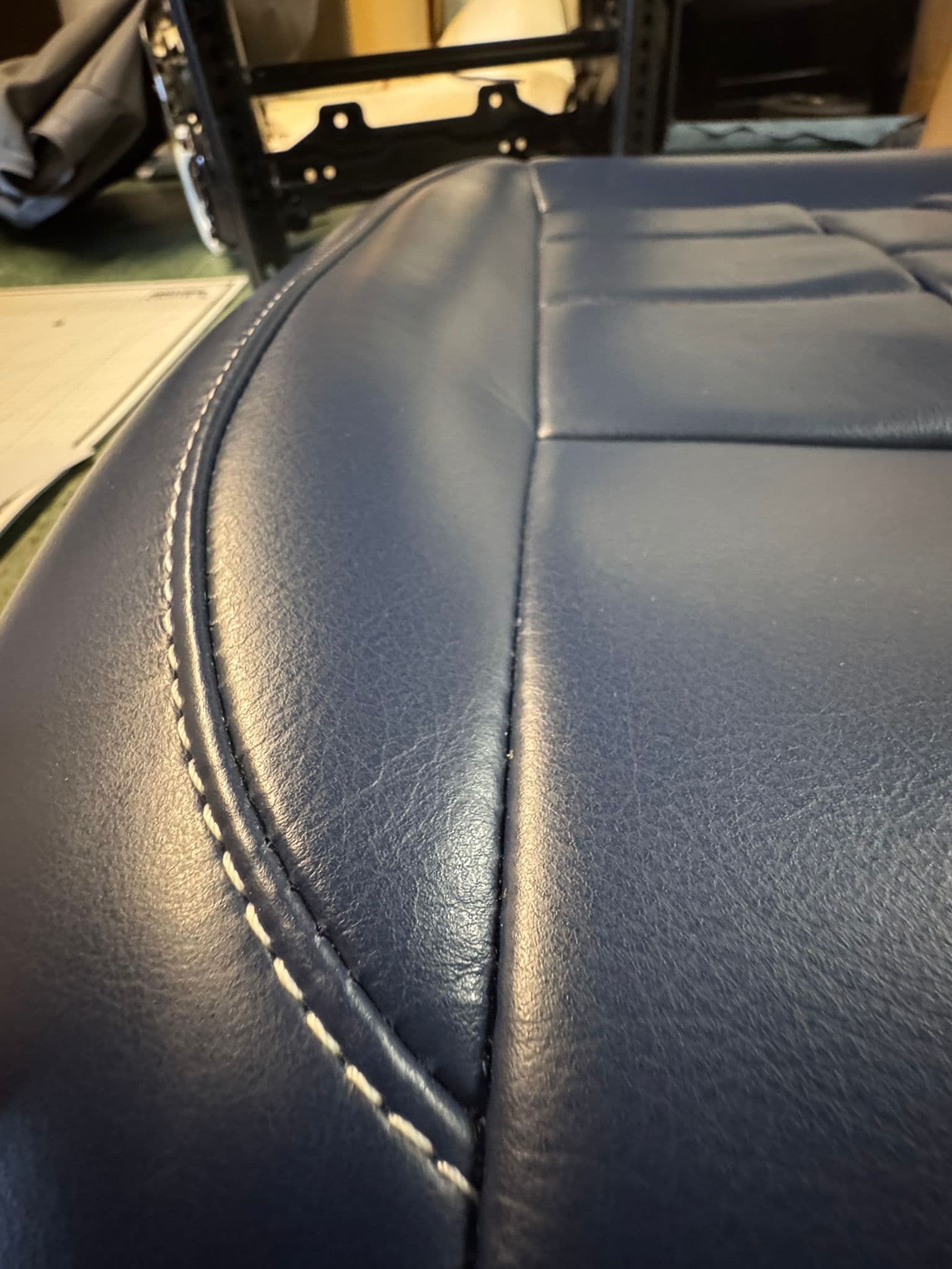 Navy leather stitch seam close-up on workbench