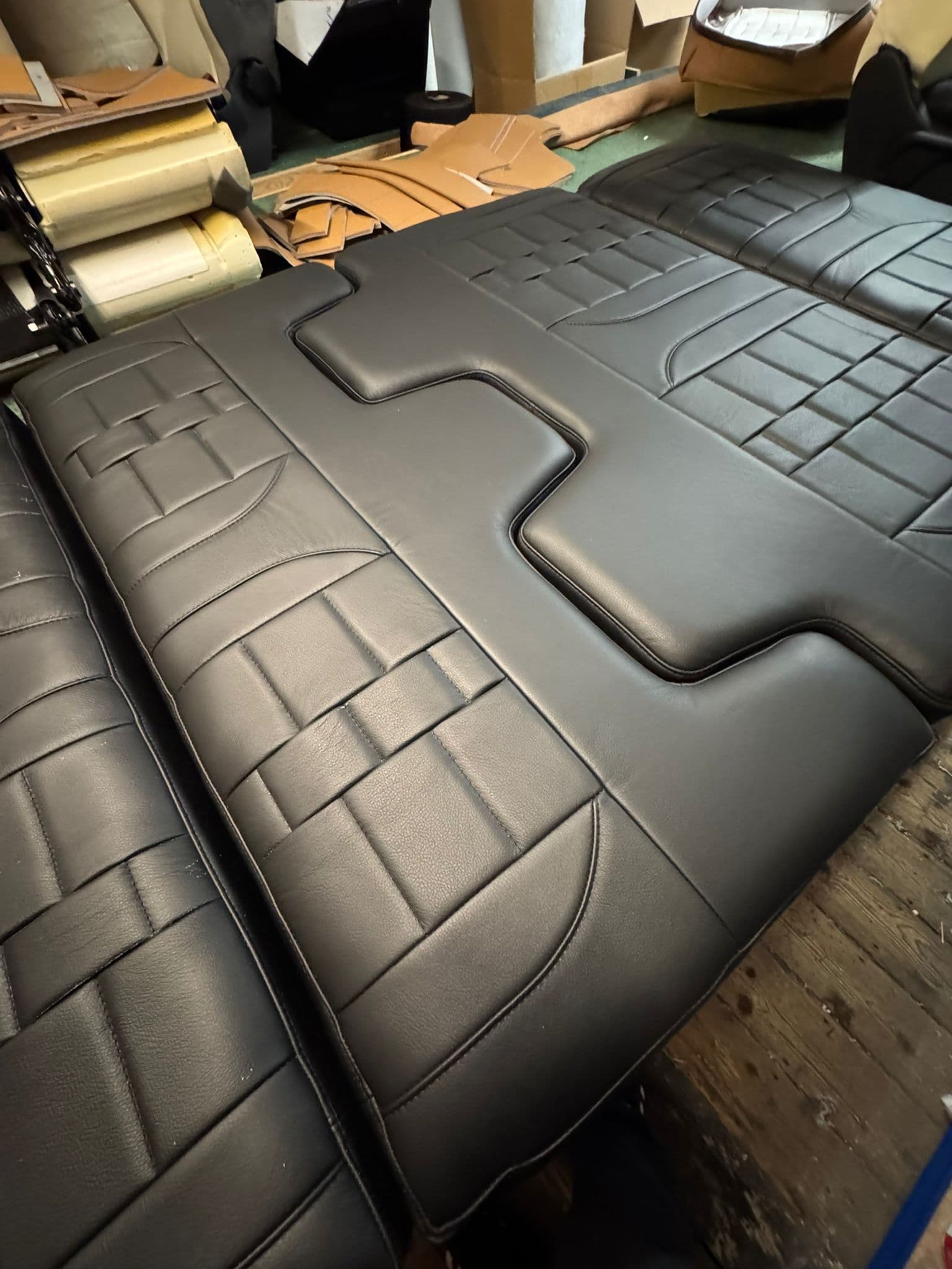 Paper pattern templates laid out on navy leather hide